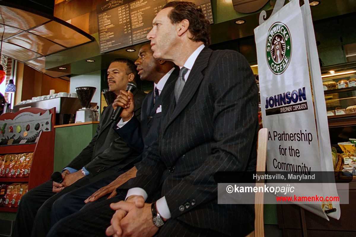 Ken Lombard, President of Johnson Development Corporation (left) and Howard Schultz, chairman and CEO of Starbucks Coffee Company (right) listen to NBA great, Earvin Magic Johnson