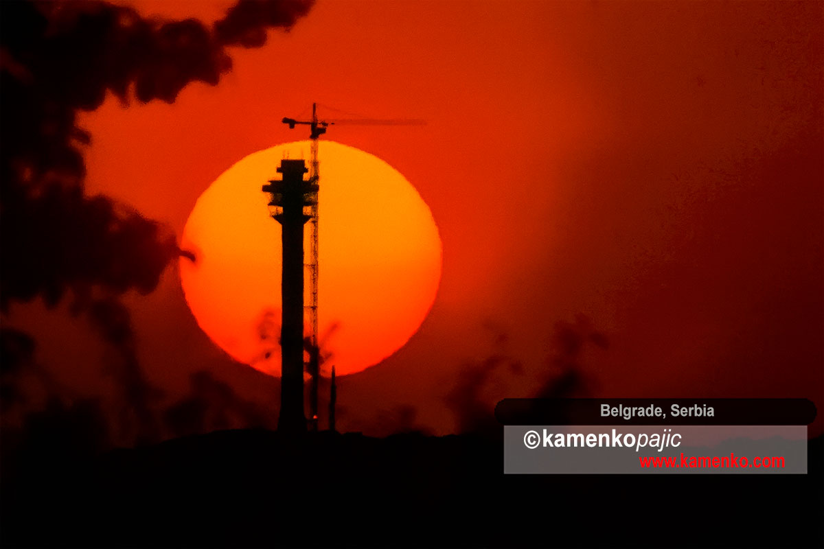 Sun rises behind silhouette of TV tower