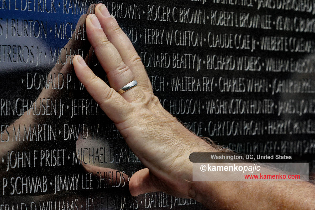 A visitor touches the Vietnam Memorial Wall