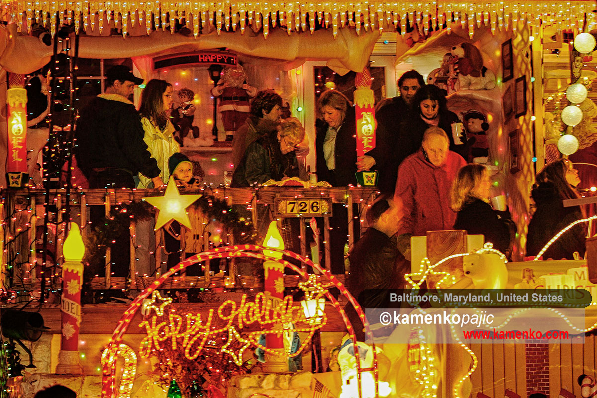 A procession of people examine an extravagantly decorated front porch