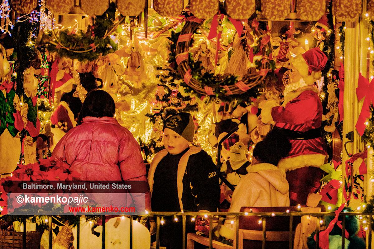 A procession of people examine an extravagantly decorated front porch