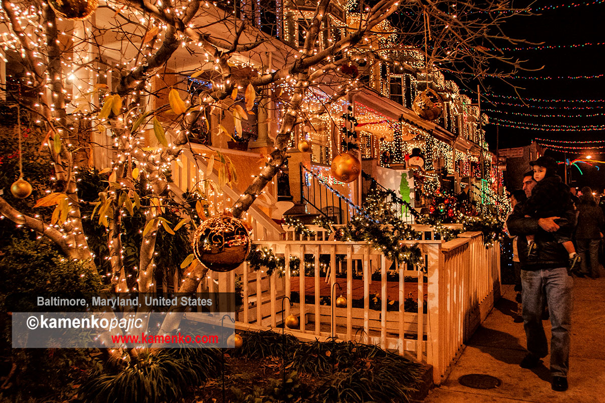 A procession of people examine an extravagantly decorated front porch