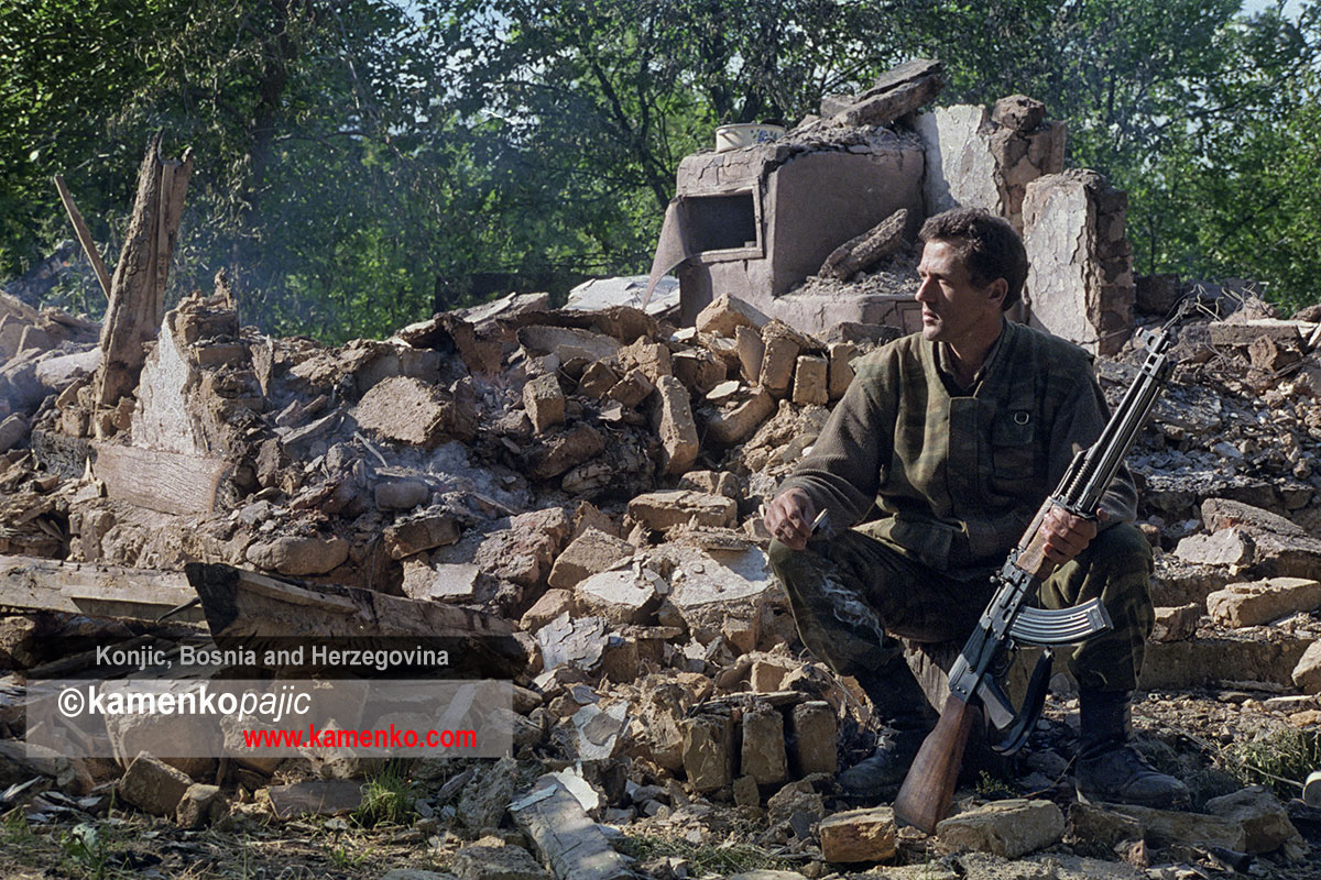 A Bosnian Serb soldier sits among the remians of his home destroyed in a Bosnian Moslem Forces raid