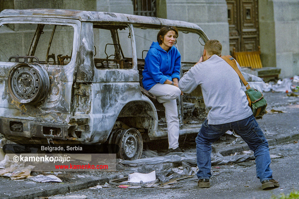 Belgraders take pictures with the remains of burned cars